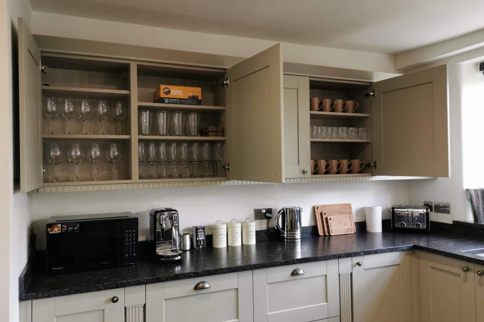 The kitchen's glassware and crockery cupboards, stocked for a full house