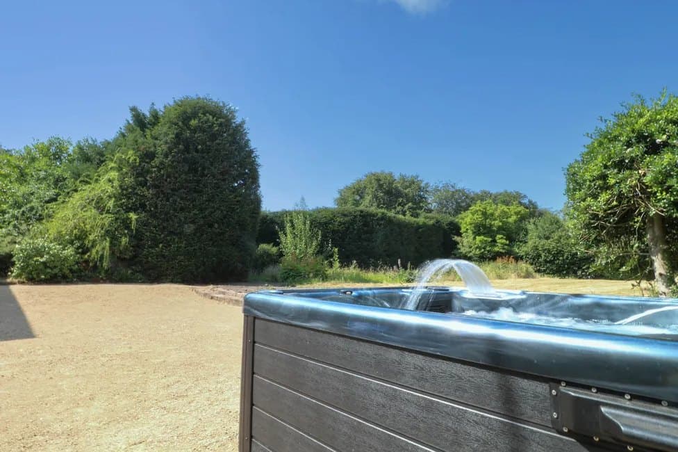 The hot tub in the grounds, screened by hedging